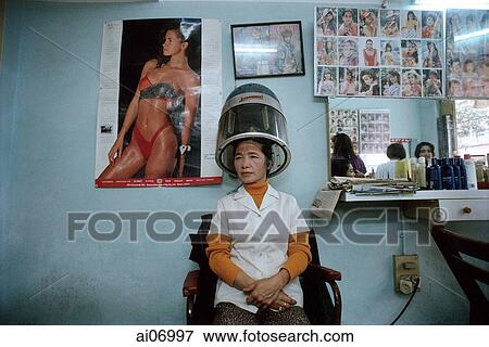 Stock Photo - Vietnam, Hanoi, woman sitting underneath hair dryer. Fotosearch