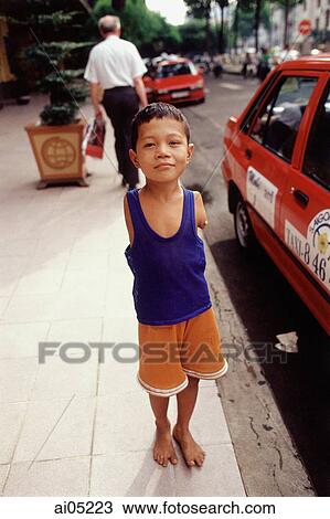 Vietnam, Ho Chi Minh City, A young boy without arms standing on a sidewalk. View Large Photo Image Stock Image - Vietnam, Ho Chi Minh City, A young boy without arms standing on a sidewalk.. Fotosearch