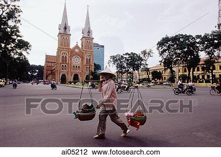 Vietnam, Ho Chi Minh City, Notre Dame Cathedral, woman crossing road with fruit baskets in foreground. View Large Photo Image Stock Image - Vietnam, Ho Chi Minh City, Notre Dame Cathedral, woman crossing road with fruit baskets in foreground.. Fotosearch