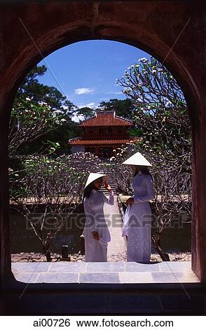 Vietnam, Hue, Tomb of Minh Mang, two young women in traditional Vietnamese dress View Large Photo Image Stock Photograph - Vietnam, Hue, Tomb of Minh Mang, two young women in traditional Vietnamese dress. Fotosearch