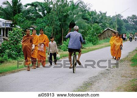 Vietnam, Mekong Delta region, Bac Lieu, Cyclist rides past Buddhist monks on road. View Large Photo Image Stock Image - Vietnam, Mekong Delta region, Bac Lieu, Cyclist rides past Buddhist monks on road.. Fotosearch