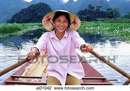 Stock Image - Vietnam, Perfume Pagoda, Hanoi, Vietnamese girl rowing a small boat. Fotosearch
