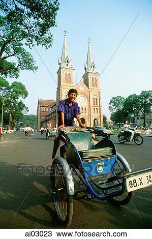 Stock Image - Vietnam, Saigon, Man on cyclo in front of Notre Dame Cathedral. Fotosearch