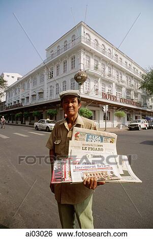 Stock Photograph - Vietnam, Saigon, newspaper vendor outside Hotel Continental. Fotosearch
