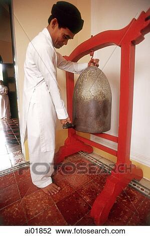 Vietnam, Tay Ninh, Cao Dai worshipper strike bell in Cao Dai Great Temple. View Large Photo Image Stock Image - Vietnam, Tay Ninh, Cao Dai worshipper strike bell in Cao Dai Great Temple.. Fotosearch