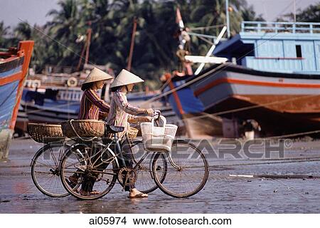 Vietnam, Women on bicycles wait for fishing boats to dock View Large Photo Image Picture - Vietnam, Women on bicycles wait for fishing boats to dock. Fotosearch