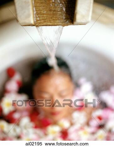Water pouring on head of woman in bathtub with flower petals View Large Photo Image Stock Photography - Water pouring on head of woman in bathtub with flower petals. Fotosearch