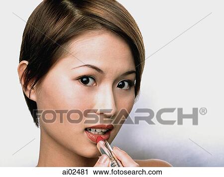 Woman applying lipstick, white background View Large Photo Image Stock Image - Woman applying lipstick, white background. Fotosearch
