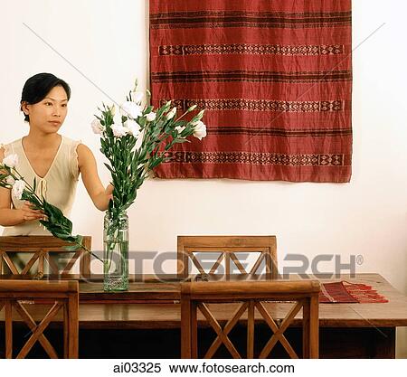 Woman arranging flowers in dining room View Large Photo Image Stock Photography - Woman arranging flowers in dining room. Fotosearch
