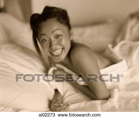 Woman covered in sheet lying in bed, laughing, portrait View Large Photo Image Stock Image - Woman covered in sheet lying in bed, laughing, portrait. Fotosearch