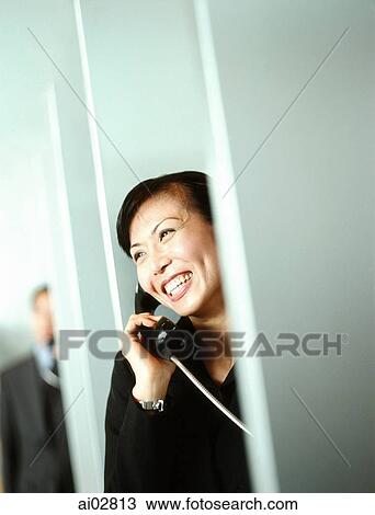 Woman executive using public telephone, male executive in background. View Large Photo Image Stock Image - Woman executive using public telephone, male executive in background.. Fotosearch