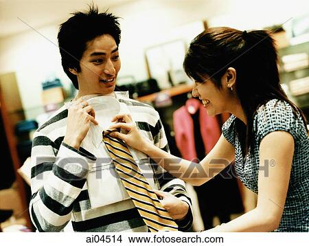 Woman helping man to choose tie at a shop View Large Photo Image Picture - Woman helping man to choose tie at a shop. Fotosearch