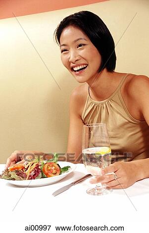 Woman holding glass at restaurant, smiling View Large Photo Image Stock Photo - Woman holding glass at restaurant, smiling. Fotosearch