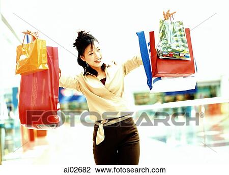 Woman holding shopping bags, smiling. View Large Photo Image Stock Image - Woman holding shopping bags, smiling.. Fotosearch
