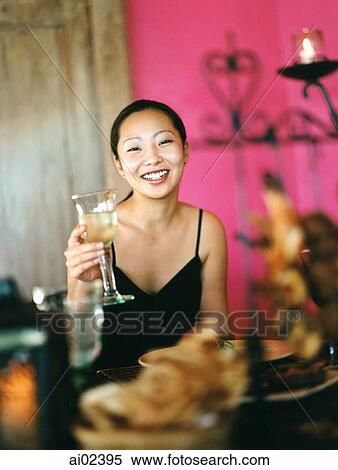 Woman holding wine glass in dining room, pink background, portrait. View Large Photo Image Stock Photography - Woman holding wine glass in dining room, pink background, portrait.. Fotosearch