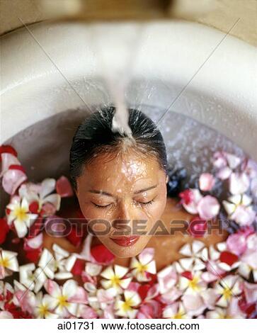 Woman in bath with floating flowers, head under running water View Large Photo Image Stock Image - Woman in bath with floating flowers, head under running water. Fotosearch