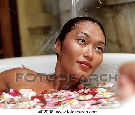 Woman in bathtub with flower petals, water pouring on hair View Large Photo Image Stock Photo - Woman in bathtub with flower petals, water pouring on hair. Fotosearch