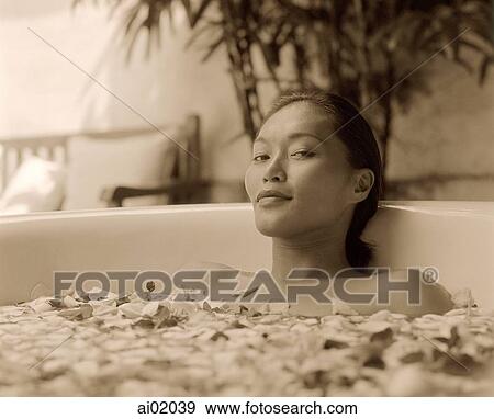 Stock Photo - Woman in bathtub with flower petals. Fotosearch