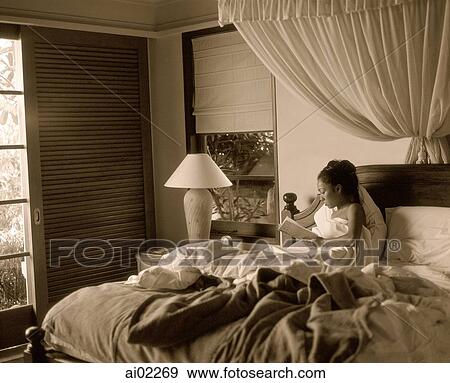 Woman in bed holding book View Large Photo Image Stock Photo - Woman in bed holding book. Fotosearch