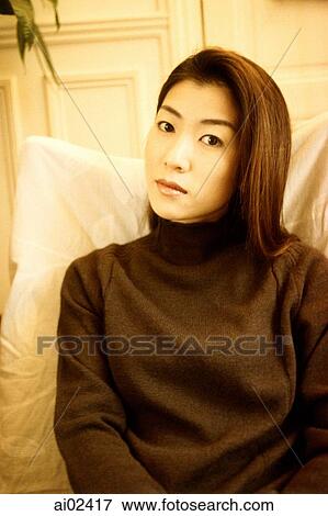Stock Photo - Woman in black turtleneck sitting, portrait.. Fotosearch