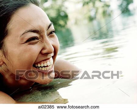 Stock Photography - Woman in water, smiling.. Fotosearch