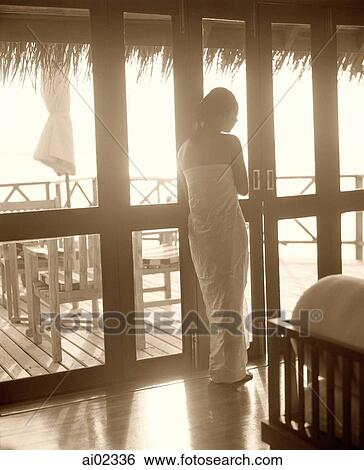 Woman leaning on door frame looking out, back towards camera, patio in background View Large Photo Image Stock Photograph - Woman leaning on door frame looking out, back towards camera, patio in background. Fotosearch