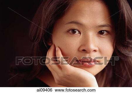 Woman looking at camera, chin on hand View Large Photo Image Stock Photograph - Woman looking at camera, chin on hand. Fotosearch