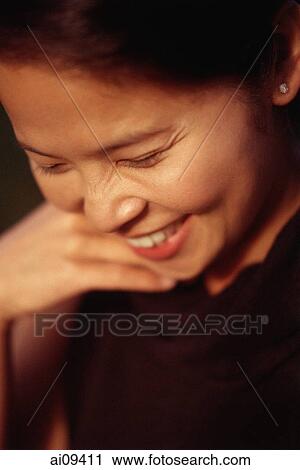 Woman looking down and smiling View Large Photo Image Stock Image - Woman looking down and smiling. Fotosearch