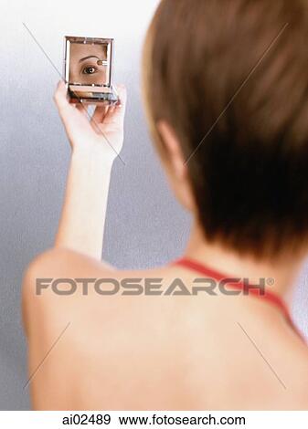 Woman looking in compact mirror, rear view View Large Photo Image Stock Photo - Woman looking in compact mirror, rear view. Fotosearch