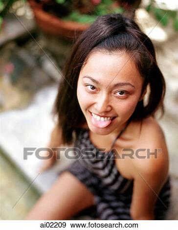 Woman making funny face, sticking out her tongue View Large Photo Image Stock Photo - Woman making funny face, sticking out her tongue. Fotosearch