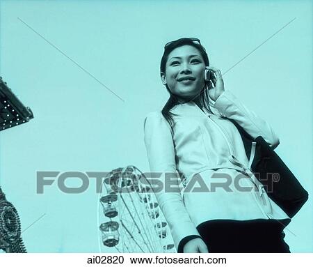 Woman on cellular phone, ferris wheel in background. View Large Photo Image Stock Image - Woman on cellular phone, ferris wheel in background.. Fotosearch