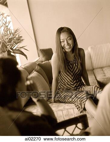 Woman on sofa talking to man View Large Photo Image Stock Image - Woman on sofa talking to man. Fotosearch