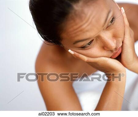 Stock Image - Woman resting chin on hands, portrait, white background. Fotosearch