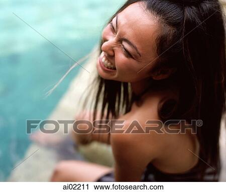 Woman sitting by side of swimming pool, laughing View Large Photo Image Stock Image - Woman sitting by side of swimming pool, laughing. Fotosearch