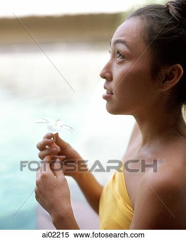 Woman sitting in swimming pool holding flower, looking off camera View Large Photo Image Stock Photography - Woman sitting in swimming pool holding flower, looking off camera. Fotosearch