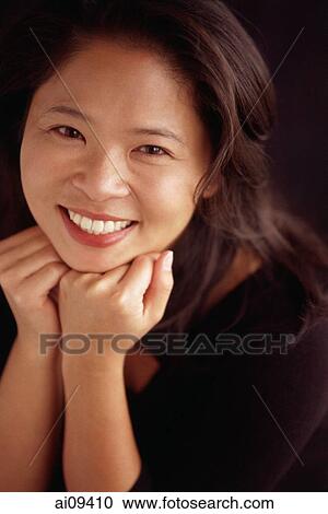 Woman smiling with chin on hands View Large Photo Image Stock Image - Woman smiling with chin on hands. Fotosearch