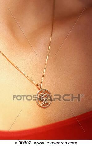 Stock Image - Woman wearing gold chain with pendant. Fotosearch
