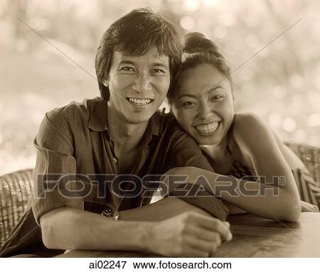 Stock Photo - Woman with arm around man, at table. Fotosearch