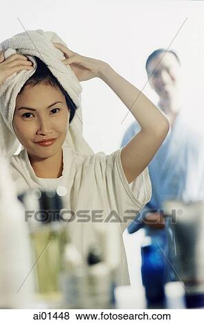 Woman with towel on head, man in background View Large Photo Image Stock Photo - Woman with towel on head, man in background. Fotosearch