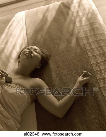 Woman wrapped in towel lying on bed View Large Photo Image Stock Photo - Woman wrapped in towel lying on bed. Fotosearch