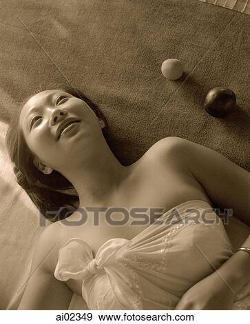 Woman wrapped in towel lying on bed View Large Photo Image Stock Photo - Woman wrapped in towel lying on bed. Fotosearch