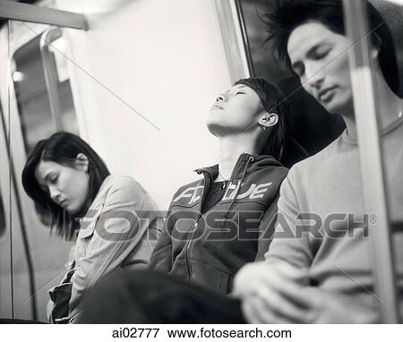 Stock Photo - Young adults sleeping on train.. Fotosearch