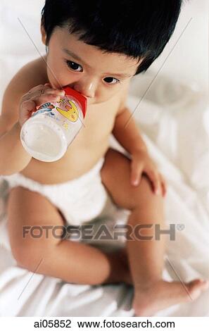 Young boy drinking milk out of a bottle, elevated view View Large Photo Image Stock Image - Young boy drinking milk out of a bottle, elevated view. Fotosearch