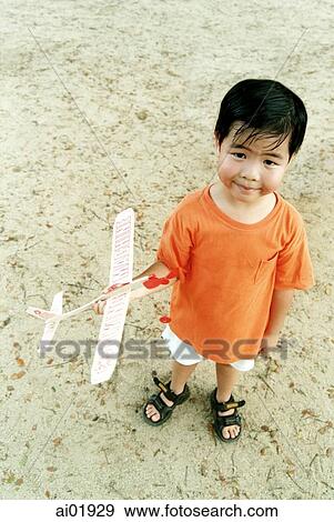Young boy holding toy airplane View Large Photo Image Stock Photo - Young boy holding toy airplane. Fotosearch