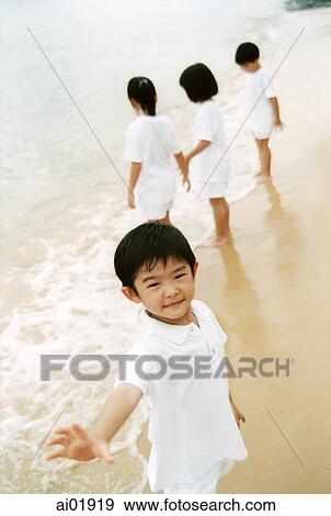 Young boy on beach, children in background View Large Photo Image Stock Photo - Young boy on beach, children in background. Fotosearch