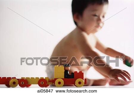 Young boy playing with toys ( high grain) View Large Photo Image Stock Photo - Young boy playing with toys ( high grain). Fotosearch