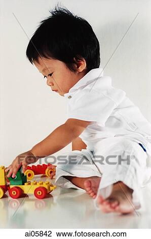 Young boy playing with toys View Large Photo Image Stock Image - Young boy playing with toys. Fotosearch