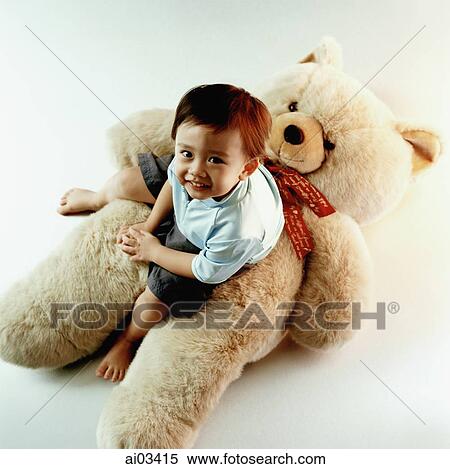 Young boy sitting on teddy bear View Large Photo Image Stock Photography - Young boy sitting on teddy bear. Fotosearch