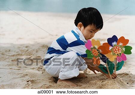 Young boy squatting on beach View Large Photo Image Stock Image - Young boy squatting on beach. Fotosearch
