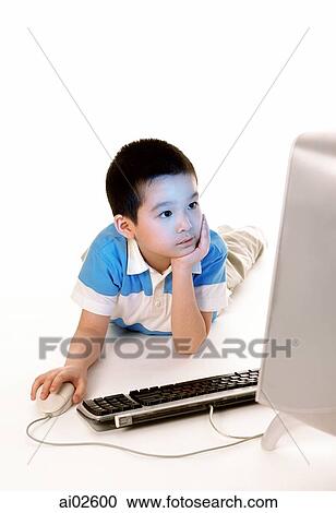Young boy using desktop computer, looking at monitor, white background. View Large Photo Image Stock Image - Young boy using desktop computer, looking at monitor, white background.. Fotosearch